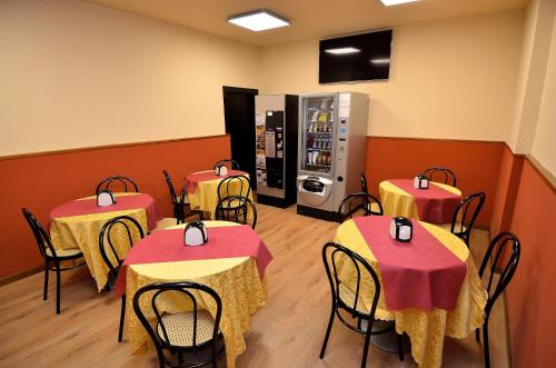 a restaurant with four tables and a soda machine at Hotel Amba Alagi in Marghera