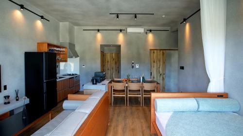 ein Zimmer mit einem Sofa und einer Küche mit einem Tisch in der Unterkunft フェリスヴィラスイート伊良部島・長浜ベイ in Miyako-jima