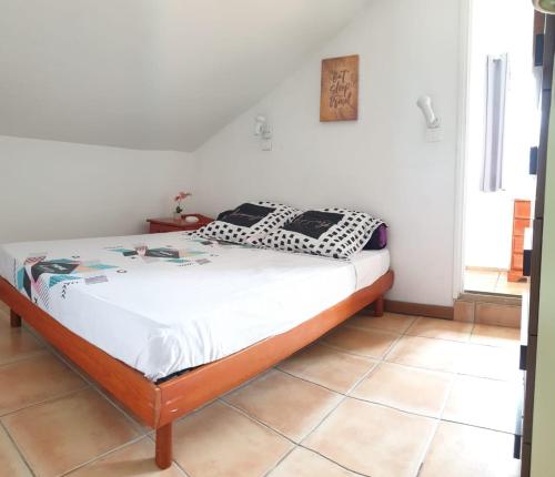 ein Schlafzimmer mit einem Bett in einem Zimmer in der Unterkunft Le tibouchina in Le Tampon