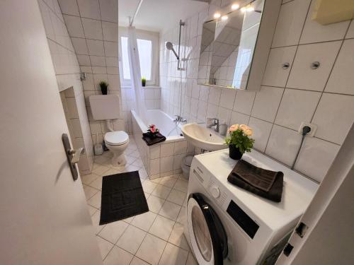 ein weißes Bad mit einer Waschmaschine in der Unterkunft ND Hotels & Apartment Düsseldorf in Düsseldorf