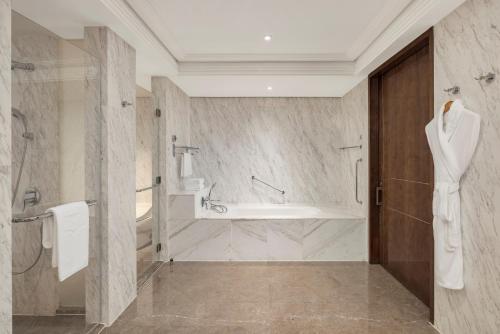 a bathroom with a tub and a shower and a sink at Midtown Shangri-La, Hangzhou - around 5 minutes walking distance to West Lake in Hangzhou