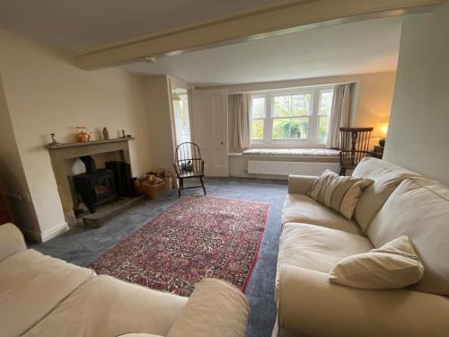 uma sala de estar com um sofá branco e uma lareira em Sandholme Cottage - Pateley Bridge em Pateley Bridge