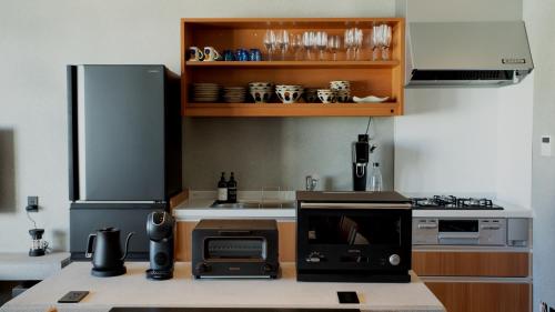 a kitchen with a refrigerator and a microwave at フェリスヴィラスイート伊良部島・長浜ベイ in Miyako Island