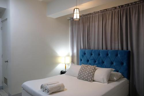 Bett mit blauem Kopfteil in einem Schlafzimmer in der Unterkunft LuxeCara Guest House in Lipa