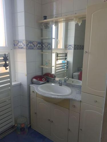 ein Bad mit einem Waschbecken und einem Spiegel in der Unterkunft Maison 3 chambres in La Frugerie