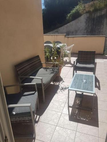 eine Terrasse mit Bänken und einem Tisch auf dem Balkon in der Unterkunft Maison 3 chambres in La Frugerie