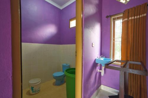 Baño púrpura con aseo y lavamanos en Tresno Sembalun, en Sembalun Lawang