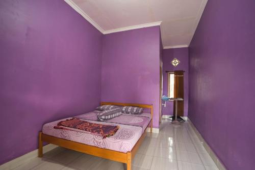 a bedroom with purple walls and a bed in a room at Tresno Sembalun Rinjani in Sembalun Lawang