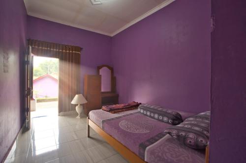 1 dormitorio con paredes de color púrpura y 1 cama en Tresno Sembalun, en Sembalun Lawang