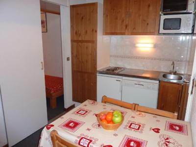 a kitchen with a table with a bowl of fruit on it at Altineige Appartements VTI in Val Thorens