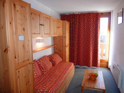 a living room with a couch and a red curtain at Altineige Appartements VTI in Val Thorens