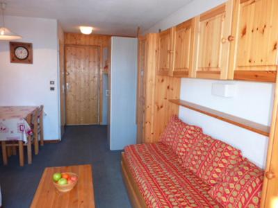 a living room with a red couch and a table at Altineige Appartements VTI in Val Thorens