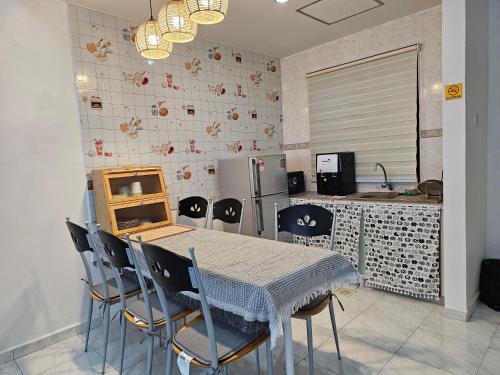 a kitchen with a table and chairs and a refrigerator at Fukuda Minshuku Japanese style in Lumut