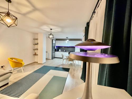 eine Küche und ein Wohnzimmer mit einem lila Stuhl in einem Zimmer in der Unterkunft YamaLuxe Apartments - Citadel Residence in Cluj-Napoca