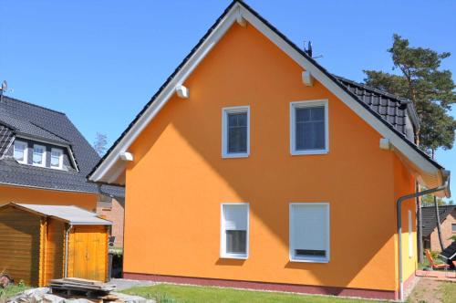 an orange house with white windows at Ferienwohnungen Appartements - Ferienhaus Müritzstern in Marienfelde