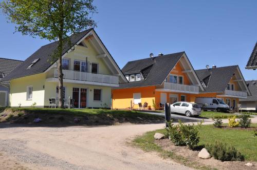 a house with a car parked in front of it at Ferienwohnungen Appartements - Ferienhaus Müritzstern in Marienfelde
