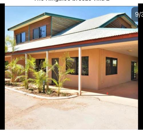 a house with a lot of palm trees in front of it at the Ningaloo breeze villa 2/10 in Exmouth