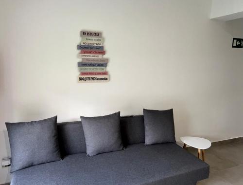 a couch in a living room with a stack of books on the wall at APARTAMENTOS EL ROJU in Santillana del Mar