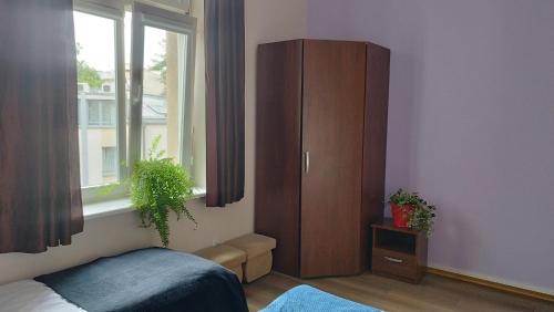 a bedroom with a bed and a cabinet and a window at Urban Nest Apartments Gertrudy 7 in Krakow