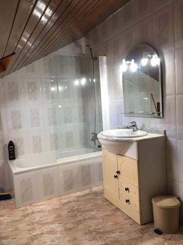 uma casa de banho com um lavatório, uma banheira e um espelho. em CASA NECHO 