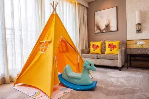 a living room with a play tent and a toy dinosaur at Midtown Shangri-La, Hangzhou - around 5 minutes walking distance to West Lake in Hangzhou