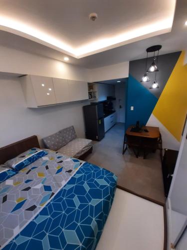 a bedroom with a blue bed and a kitchen at 1809 Sunvida Tower Condo across SM City Cebu in Cebu City