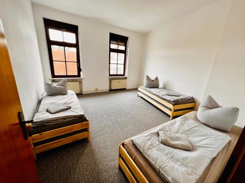 um quarto com duas camas e duas janelas em Mitten im Herzen em Schönebeck