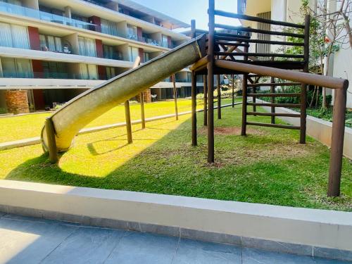 a slide in a park in front of a building at Dolce vita luxurious apartment in Umhlanga