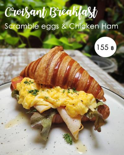 a croissant breakfast with scramble eggs and chicken on a plate at Phranakorn-Nornlen in Bangkok