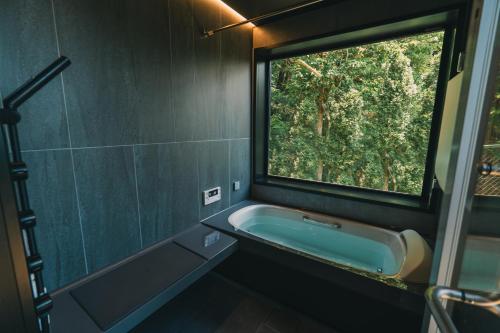 サウナ付き大人の隠れ家 -Kito NASU- في ناسو: حمام مع حوض استحمام ونافذة