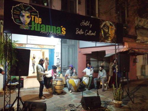 a group of people playing drums in front of a building at The juannas hostal y bistro cultural in Rivera
