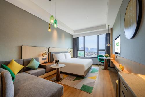 西安市にあるHoliday Inn Xi'an East, an IHG Hotelのベッドとソファ付きのホテルルーム