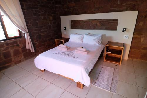 a bedroom with a white bed with two towels on it at Duwisib Guest Farm in Duwisib