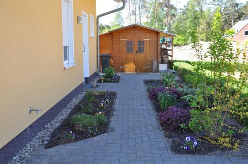 un jardín frente a una casa con un edificio en Ferienwohnungen Appartements - Ferienhaus Müritztraum, en Marienfelde