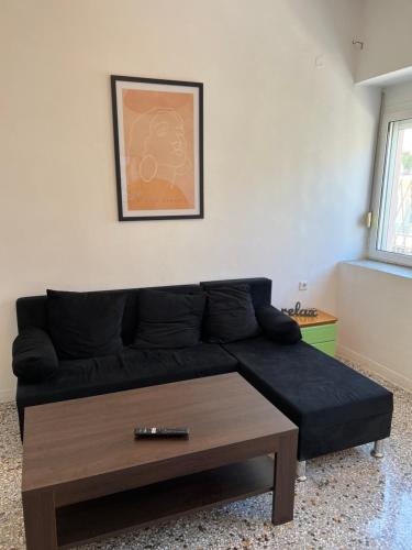 Sala de estar con sofá negro y mesa de centro en Sunchaser Apartments, en Igoumenitsa