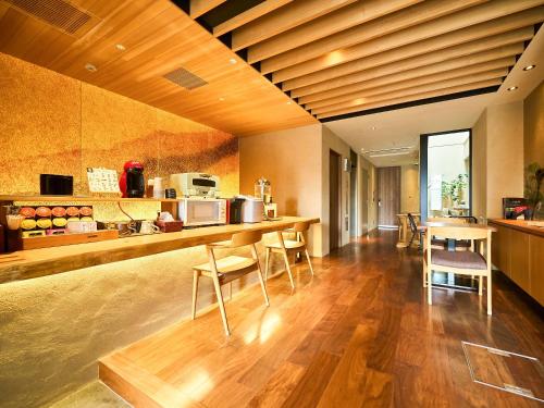 una cucina con pavimenti in legno e bancone con sedie di 枳殻の杜 Kikoku no mori a Kyoto