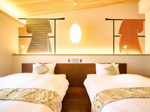 two beds in a hotel room with white sheets at 枳殻の杜 Kikoku no mori in Kyoto