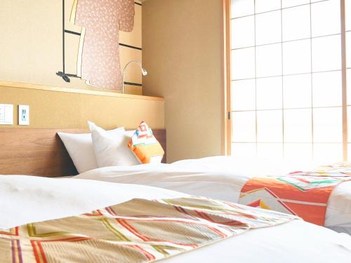 a hotel room with two beds and a window at 枳殻の杜 Kikoku no mori in Kyoto