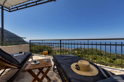 a balcony with a bed and a table and a view of the ocean at Cottage Baskovic in nature park in Makarska