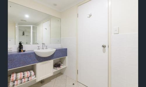 een witte badkamer met een wastafel en een douche bij Charming 1 bedroom Apt - Close to Town & Beach in Port Douglas