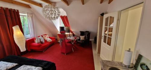 a living room with a red couch and a red chair at Am alten Siel in Wilhelmshaven