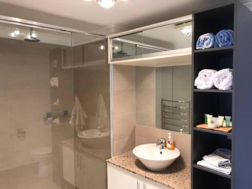 a bathroom with a sink and a toilet and a mirror at Yellow Boat Harbour Beach Apartment in Boat Harbour