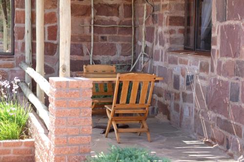a wooden chair sitting next to a brick wall at Duwisib Guest Farm in Duwisib
