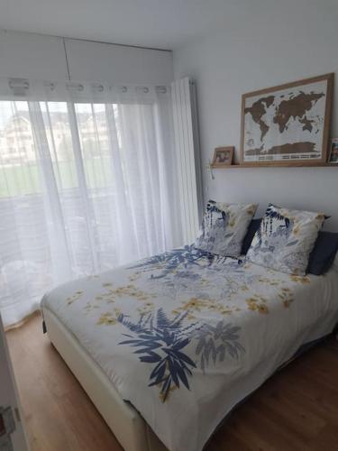 een slaapkamer met een bed met een blauwe en witte deken bij Near GVA: cosy & luminous cocoon in Ferney-Voltaire
