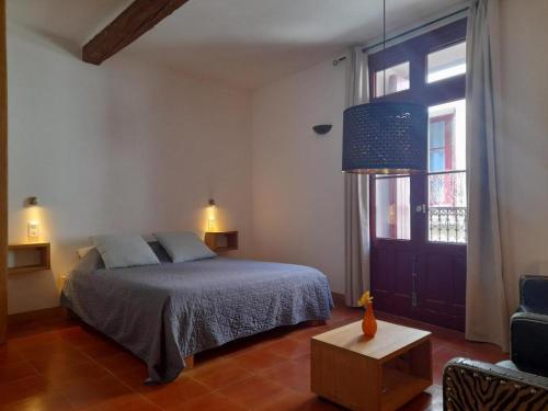 ein Schlafzimmer mit einem Bett und einem großen Fenster in der Unterkunft Les Studios de St Guilhem in Saint-Guilhem-le-Désert