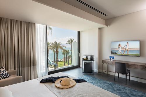 a bedroom with a bed and a desk and a large window at U Boutique Kinneret by the Sea of Galilee in Tiberias