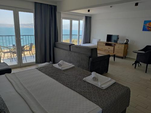 Ni Marin Hotel في Milas: غرفة فندقية بسرير وإطلالة على المحيط