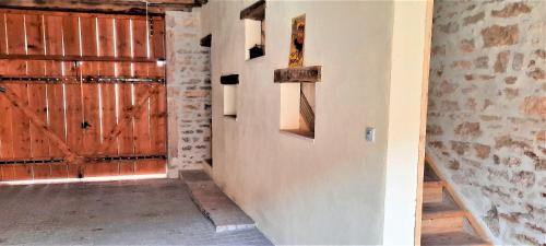 a hallway with a wooden door in a barn at Le Cocoon avec parking gratuit in Cuisery