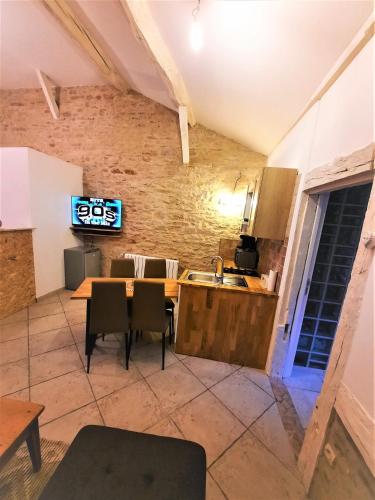 Il comprend une cuisine et une salle à manger avec une table et une télévision. dans l'établissement Le Cocoon avec parking gratuit, à Cuisery