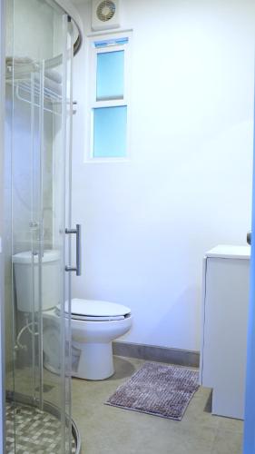 a bathroom with a toilet and a glass shower at Estudio Central London Consulado in Tijuana